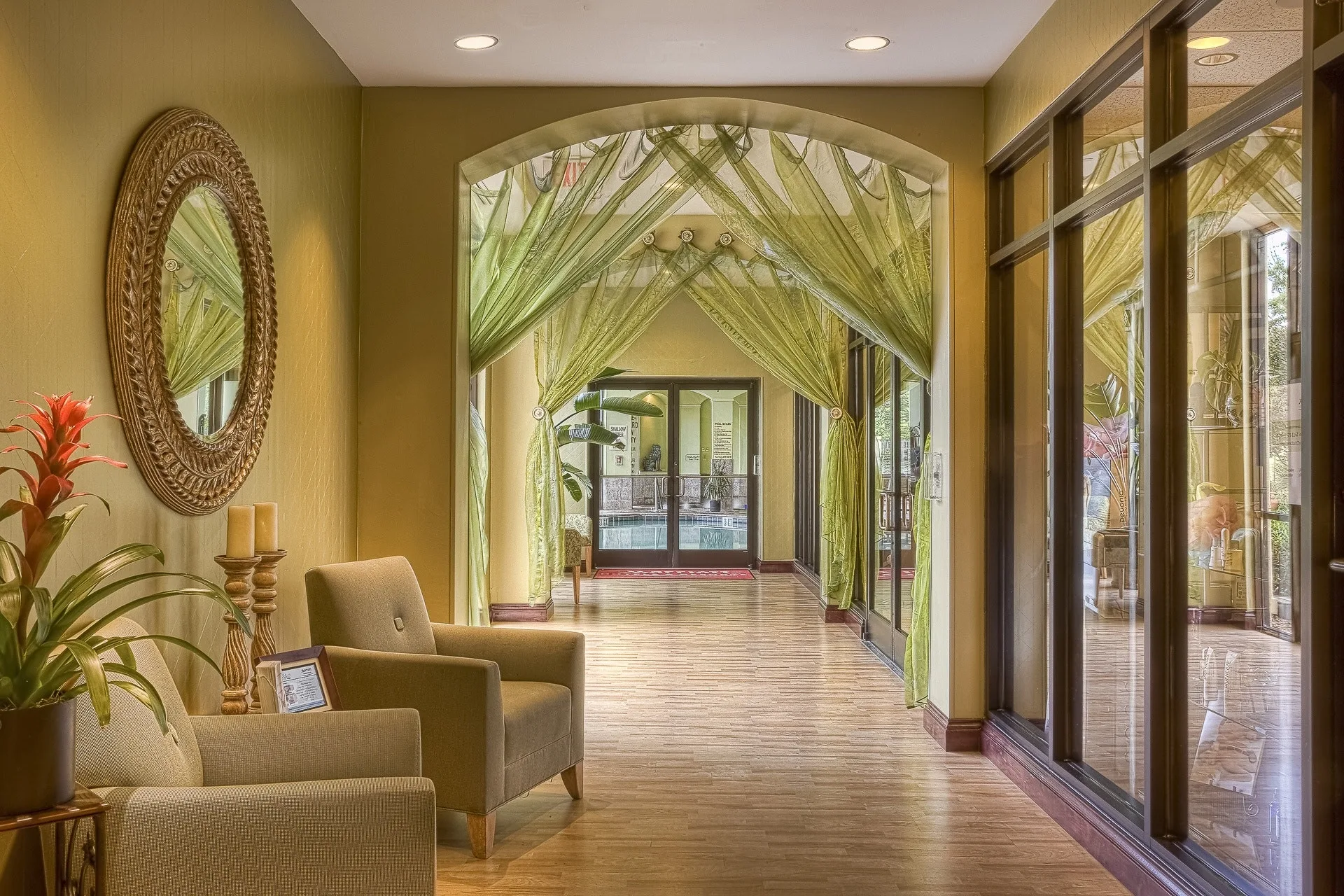 Sheer green draperies framing a furnished interior with seating